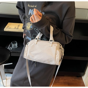 Dettaglio borsa bowling grigio chiaro con motivo geometrico, manici e tasca laterale