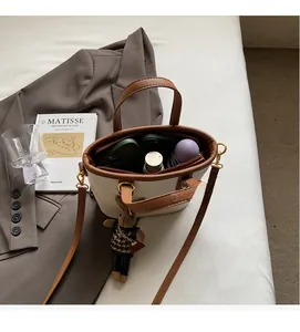 Detail of white bucket bag interior showing spacious capacity for phone and umbrella
