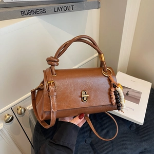 Sac baguette vintage en cuir marron texturé avec fermoir doré et gland en perles