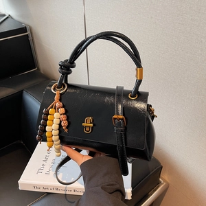 Sac baguette vintage en cuir noir avec charm perlé et fermoir pivotant doré chic