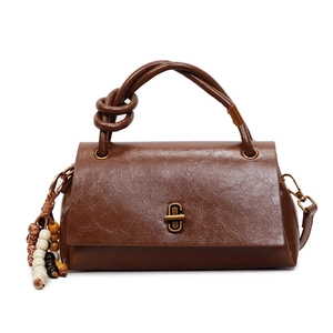 Vintage brown leather crossbody handbag with gold oval twist lock and beaded charm