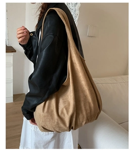 Model wearing large khaki suede hobo bag showing its size and natural drape on shoulder