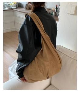 Detail of camel suede tote bag worn over shoulder showing slouchy hobo texture and large size