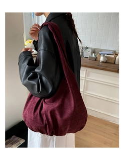 Burgundy corduroy oversized tote bag styled with a leather jacket in a cozy indoor setting