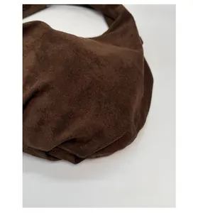 Close-up of brown faux suede tote bag featuring smooth matte texture and soft folds