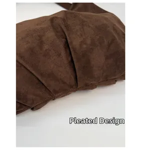 Detailed view of dark brown faux suede material featuring unique pleated design texture