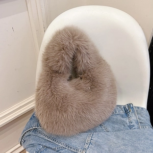 Minimalist faux fur tote bag in soft khaki plush texture on a denim jacket background