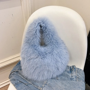 Light blue faux fur handbag on white chair with soft plush texture for autumn fashion