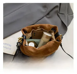 Capacité intérieure d'un sac seau en daim marron avec cordon de serrage et dorures