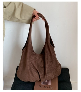 Detail of soft brown suede tote bag featuring a spacious interior and minimalist design