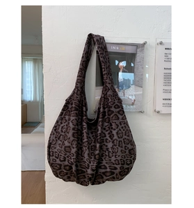 Detail of large capacity leopard print hobo bag with wide shoulder strap and soft texture