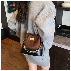 Détail du sac seau vintage avec daim marron matelassé et chaîne dorée élégante