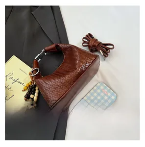 Macro shot of dark brown woven leather hobo bag texture with beaded tassel decoration