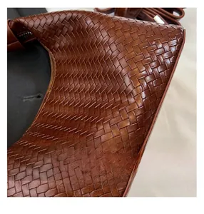 Close-up of premium dark brown woven leather texture on a stylish luxury handbag