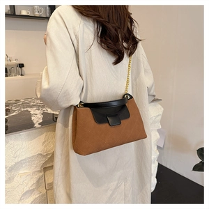 Detailed back view of a brown plaid crossbody bag with gold chain strap on a model