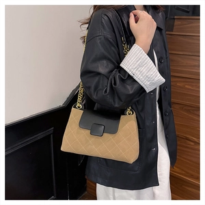 Detail of khaki plaid shoulder bag with black leather flap and gold chain strap