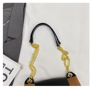 Detail of crossbody bag featuring gold chain strap and quilted brown suede texture