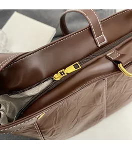 Close-up of golden zipper and textured brown PU leather on large tote bag