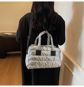 Close-up of metallic silver quilted tote bag with bubble texture and black strap
