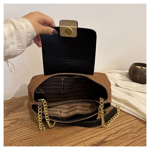 Detail view of the brown shoulder bag's interior lining and golden chain strap