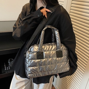 Macro view of metallic silver quilted tote bag showing padded texture and strap details