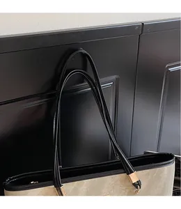 Detail of smooth leather shoulder strap and canvas texture with golden hardware