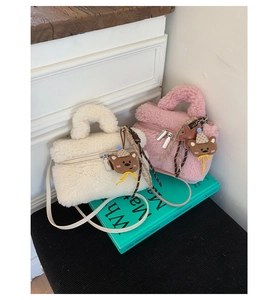 Detailed macro of plush faux fur mini bags in cream and pink with bear charms and straps