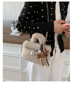 Close-up of plush beige mini handbag with cute cartoon bear and star bag charms