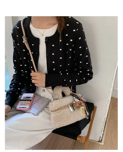 Detail of plush beige crossbody bag with furry texture, silver zipper and cute bear charm