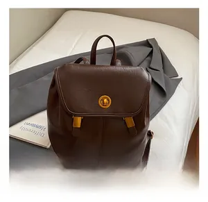 Gros plan du sac à dos vintage marron foncé avec fermoir rotatif doré et boucles en métal