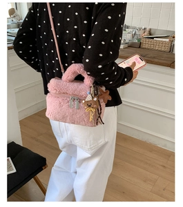 Detailed view of pink plush mini bag with bear charm and adjustable shoulder strap