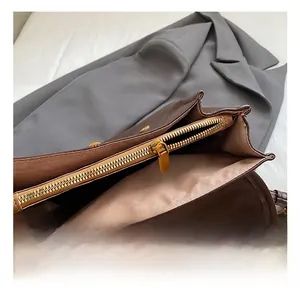 Détail de la fermeture éclair dorée et de la doublure intérieure du sac à dos en cuir brun