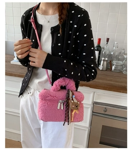 Detailed view of pink plush crossbody bag with cute bear charm and chain strap