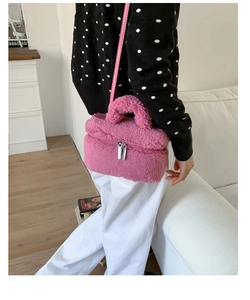 Detail view of pink plush crossbody bag with teddy fur texture and dual metal zippers