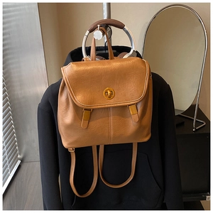 Detail eines braunen Lederrucksacks mit goldenem Drehverschluss und Vintage-Schnalle