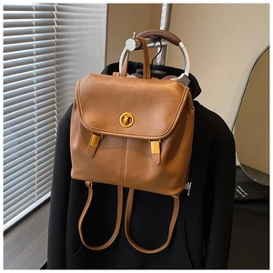 Nahaufnahme eines braunen PU-Lederrucksacks mit goldenem Ringverschluss und Vintage-Textur
