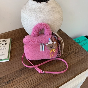 Detail of pink faux fur crossbody bag with silver double zippers and cute bear charm
