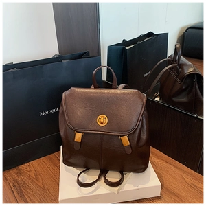 Nahaufnahme des dunkelbraunen Lederrucksacks mit goldenem Drehverschluss und feiner Textur