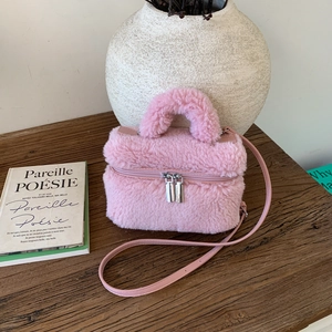 Close-up of pink faux fur mini handbag with leather handles and double metal zippers