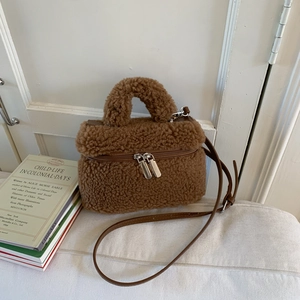Brown plush mini square handbag with top handle and leather strap on white soft surface