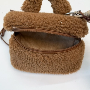 Detail of soft brown faux shearling mini bag with zipper and leather strap