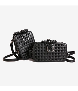 Detail of black pebbled leather crossbody bags with punk studs and silver U-shaped metal buckles