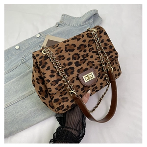 Close-up of leopard print shoulder bag with gold metal buckle and leather chain strap