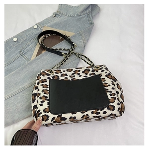 Detailed view of leopard print crossbody bag with metallic chain strap and black front pocket