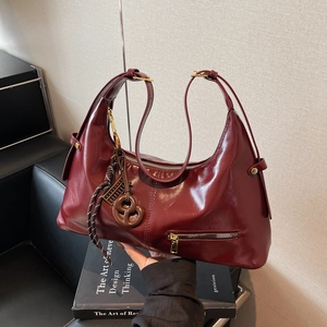 Sac hobo élégant en cuir rouge vin avec fermeture éclair dorée et pompon à perles