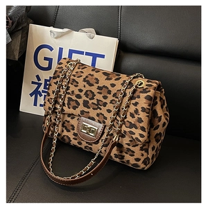 Close-up of leopard print crossbody bag with golden chain strap and twist lock detail