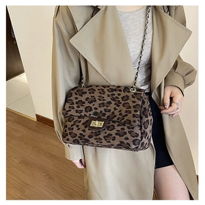 Detail of leopard print shoulder bag featuring a gold metal twist lock and chain strap