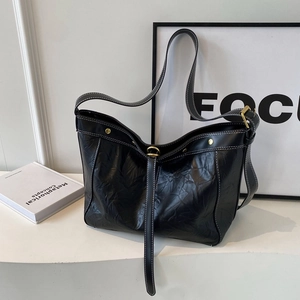 Retro black leather pleated tote bag with white stitching and long shoulder strap