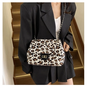 Detail view of the leopard print crossbody bag with gold chain strap and turn-lock closure