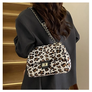 Detail of leopard print shoulder bag featuring a gold clasp and metal chain strap